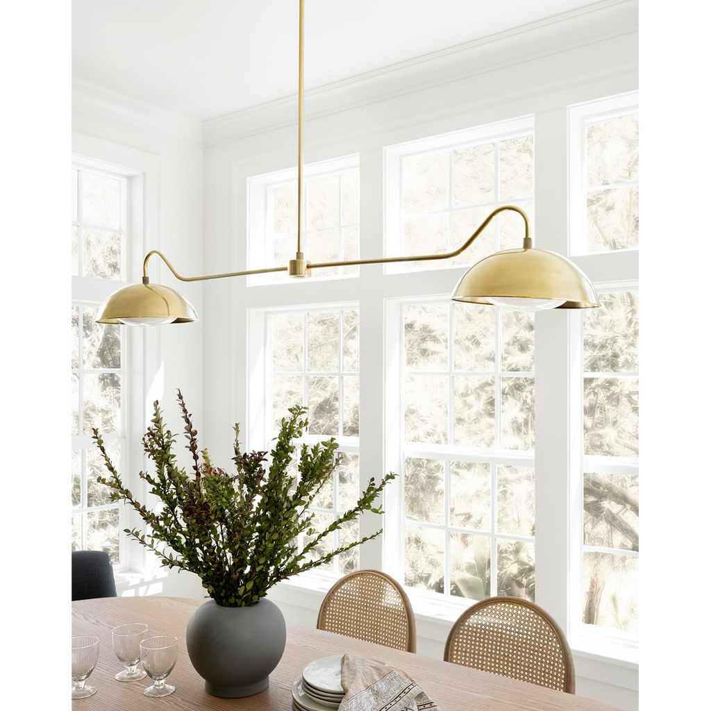 Aldorno linear chandelier with brass finish and round shallow shades.
