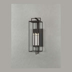 Black forged iron clear glass outdoor wall lantern sconce mounted on a white exterior patio wall with black framed doors and windows.