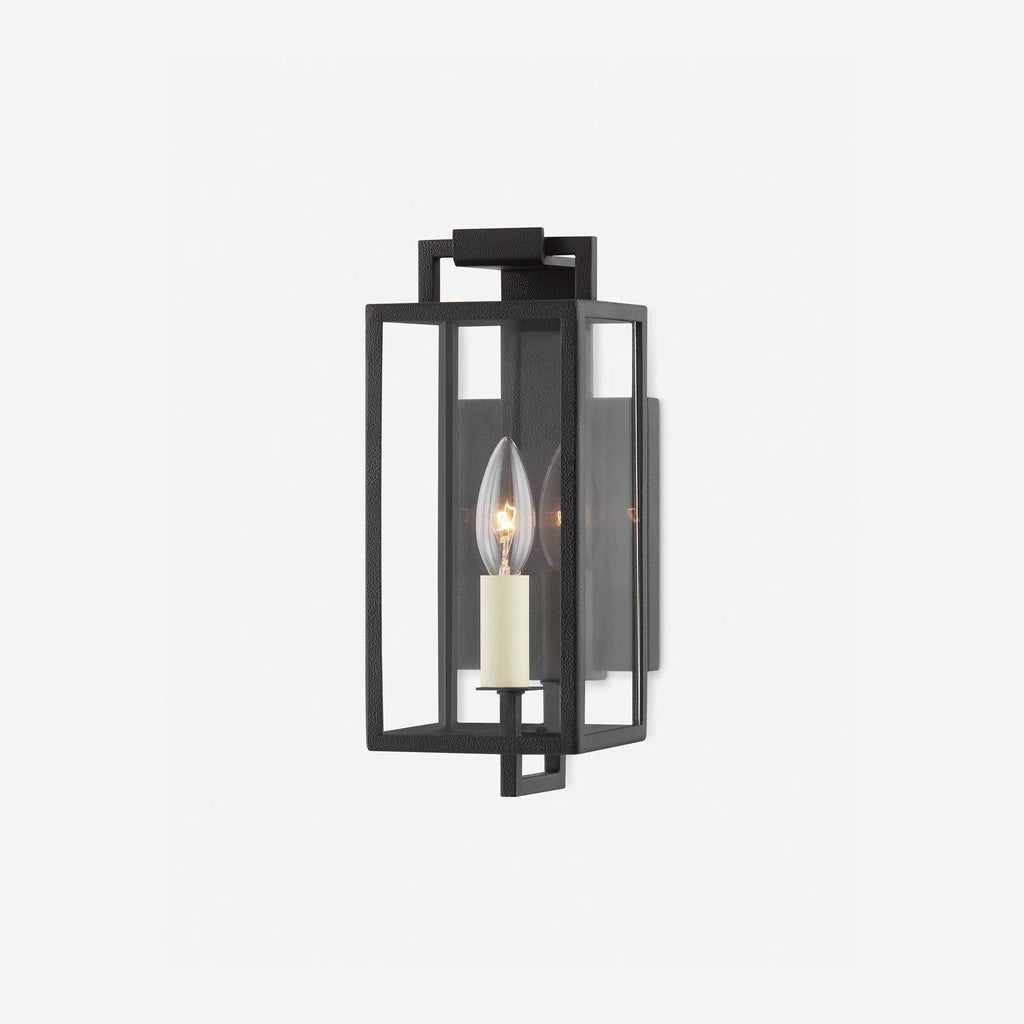 Black forged iron clear glass outdoor wall lantern sconce mounted on a white exterior patio wall with black framed doors and windows.