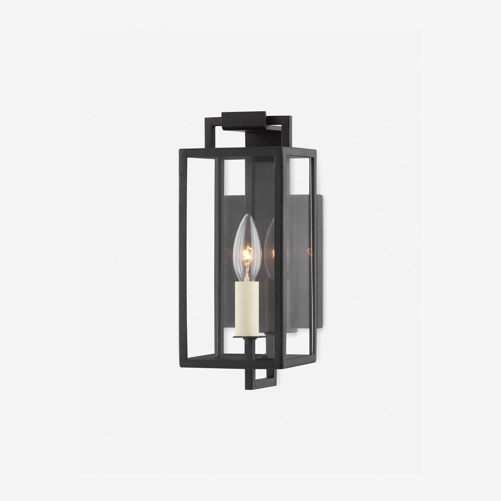 Black forged iron clear glass outdoor wall lantern sconce mounted on a white exterior patio wall with black framed doors and windows.