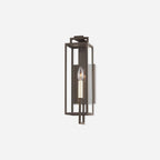 Black forged iron clear glass outdoor wall lantern sconce mounted on a white exterior patio wall with black framed doors and windows.